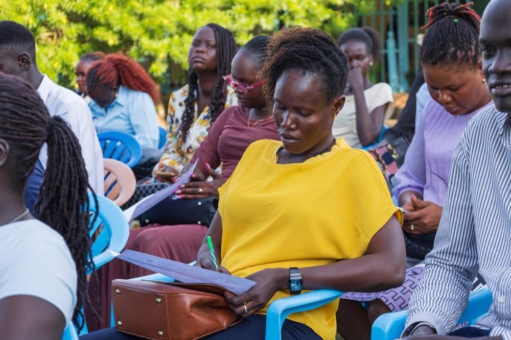 Young South Sudanese participants read and take notes together during a learning session