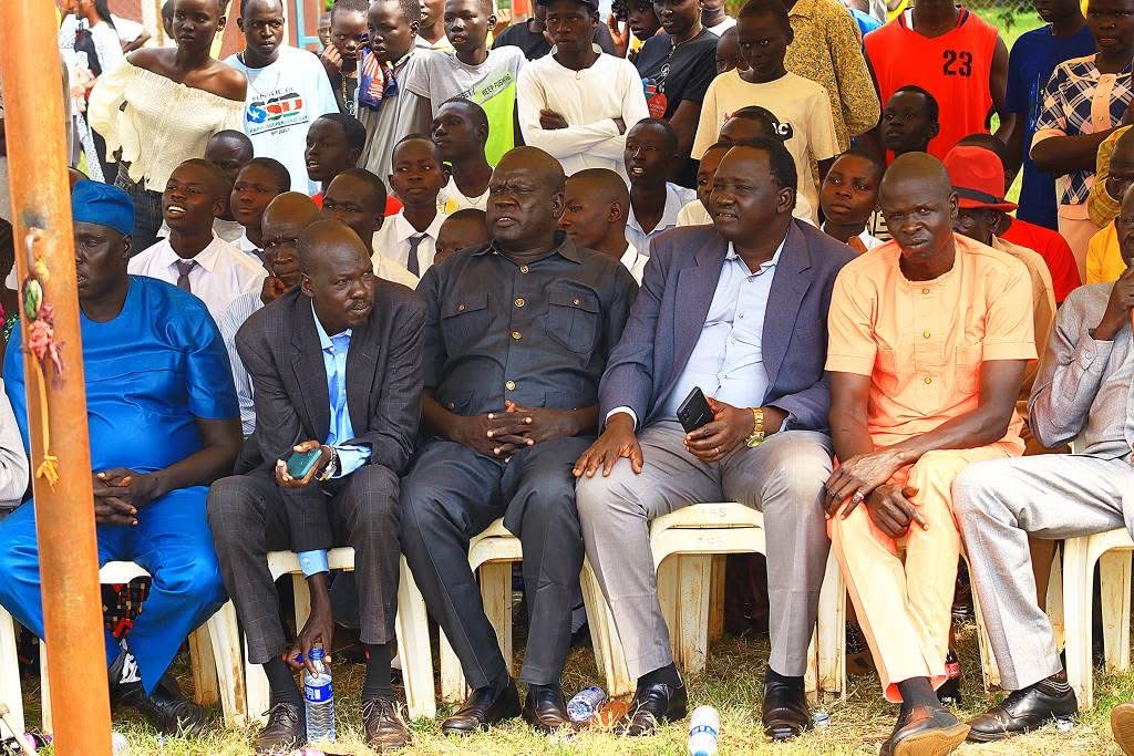 Community leaders and elders seated with young people gathered behind them at Peace Cultural Day