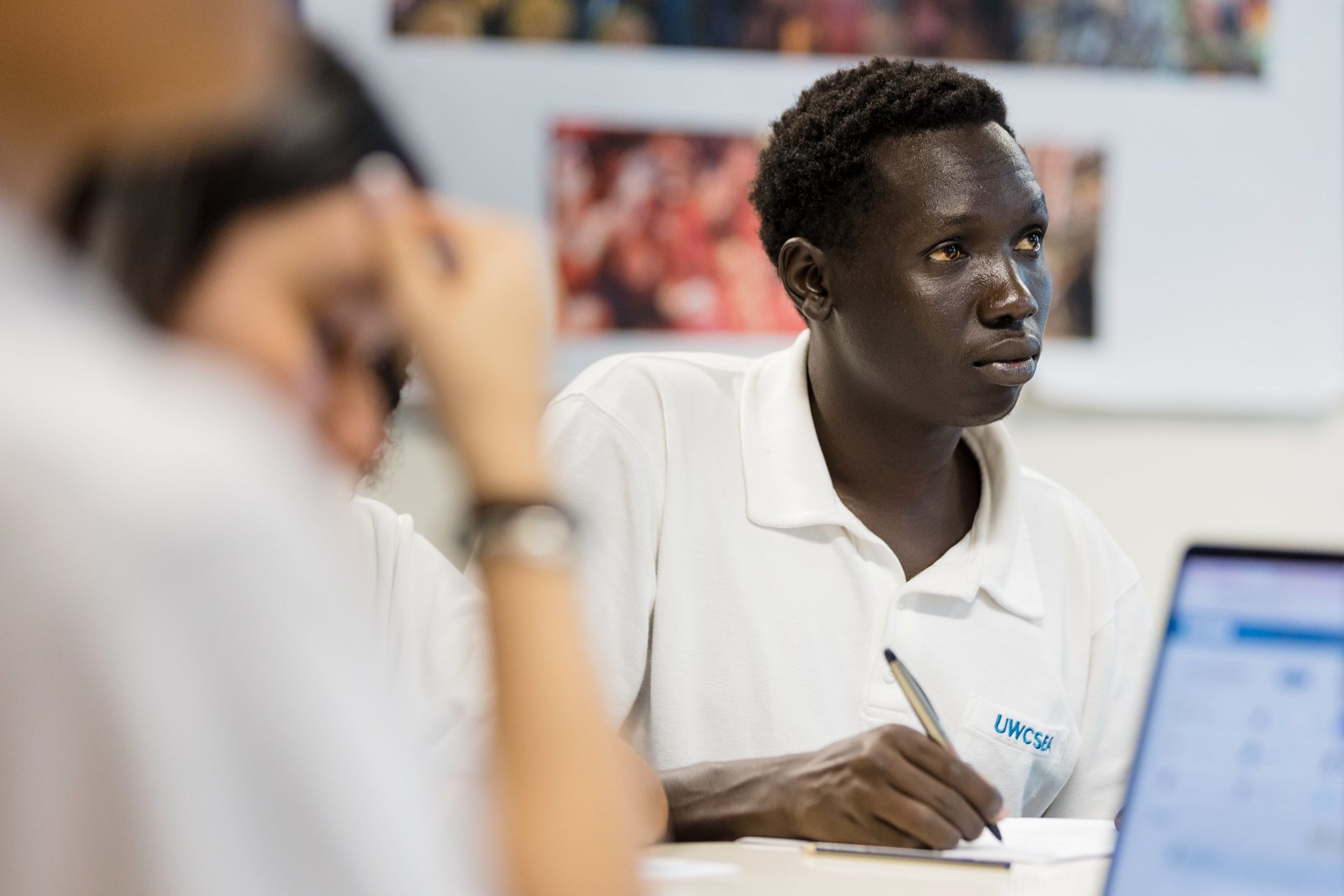 Deng Aguer Bul takes notes in a classroom at UWC South East Asia